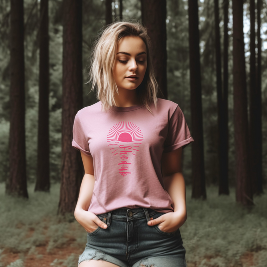 A bright sunset motif on the front of a pink t shirt, Shedub brand as the ripple in the water