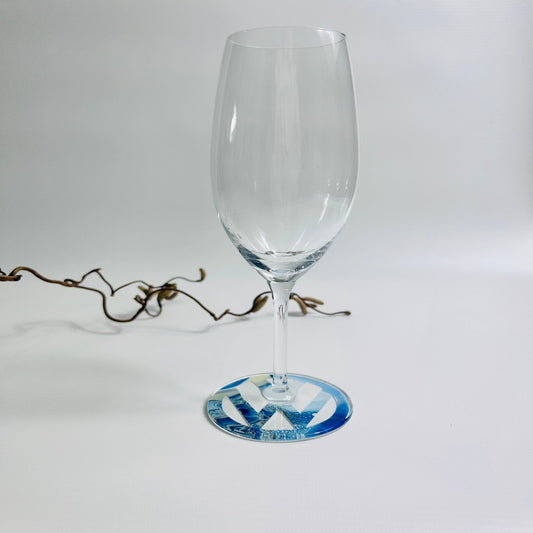 Prosecco glass with blue fluid art logo on the base, sealed in resin