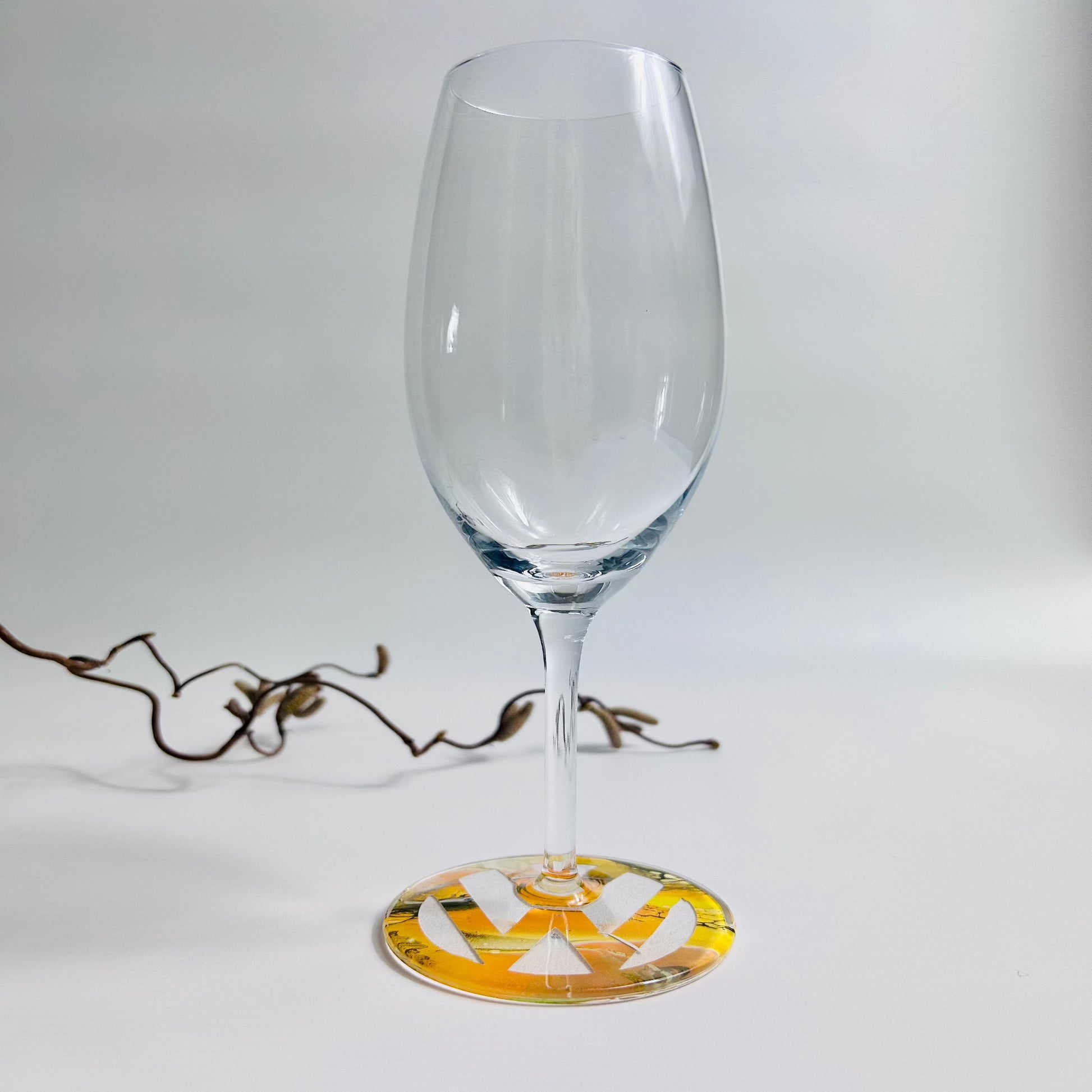 Prosecco glass with yellow fluid art logo on the base, sealed with resin