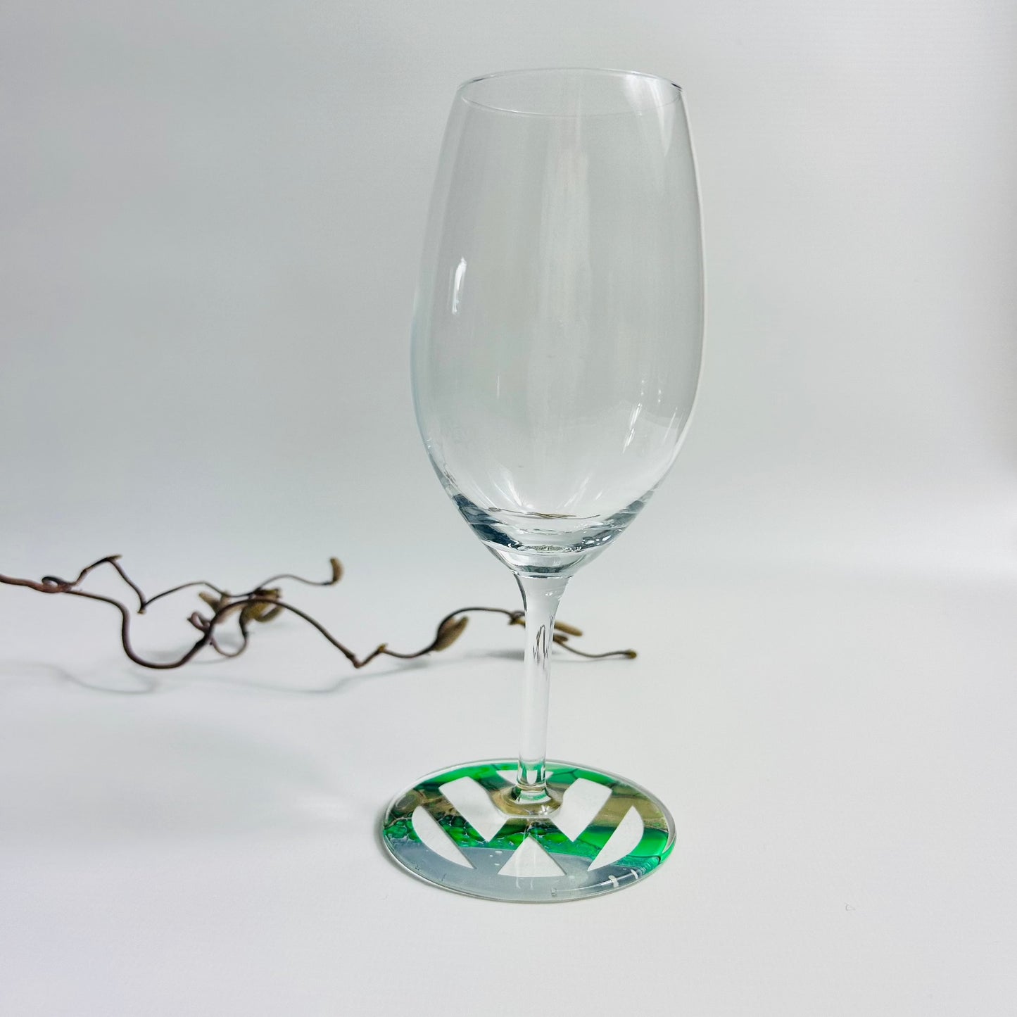 Prosecco glass with green fluid art logo on the base, sealed with resin
